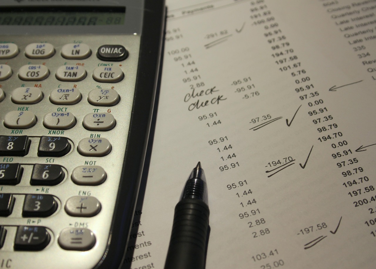 Calculadora, cartão e documentos financeiros mostrando contas para comparar qual método reduz dívidas mais rápido.