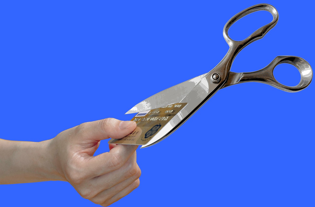 Cartão de crédito com tesoura, para comparar o custo da dívida com o benefício de guardar o 13º
