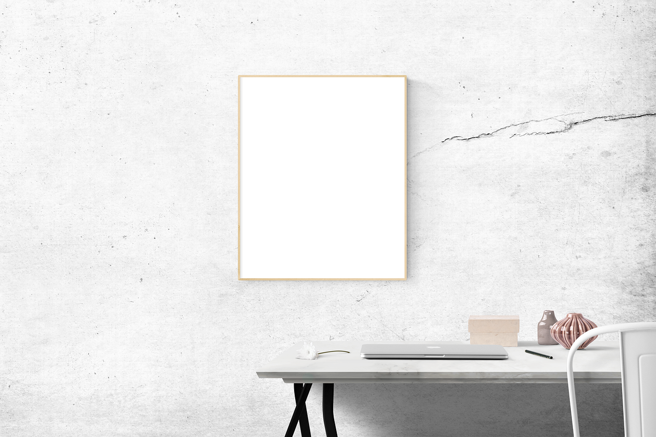 Mesa com notebook e quadro em branco, útil para montar sua planilha de dívidas do zero